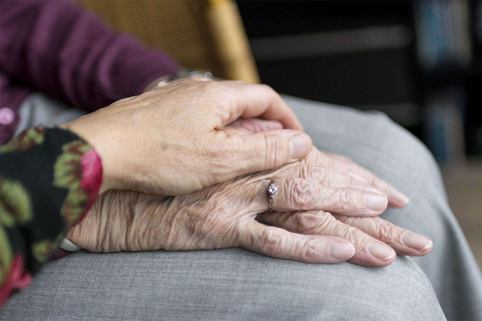 carer with hands rested on top of resident