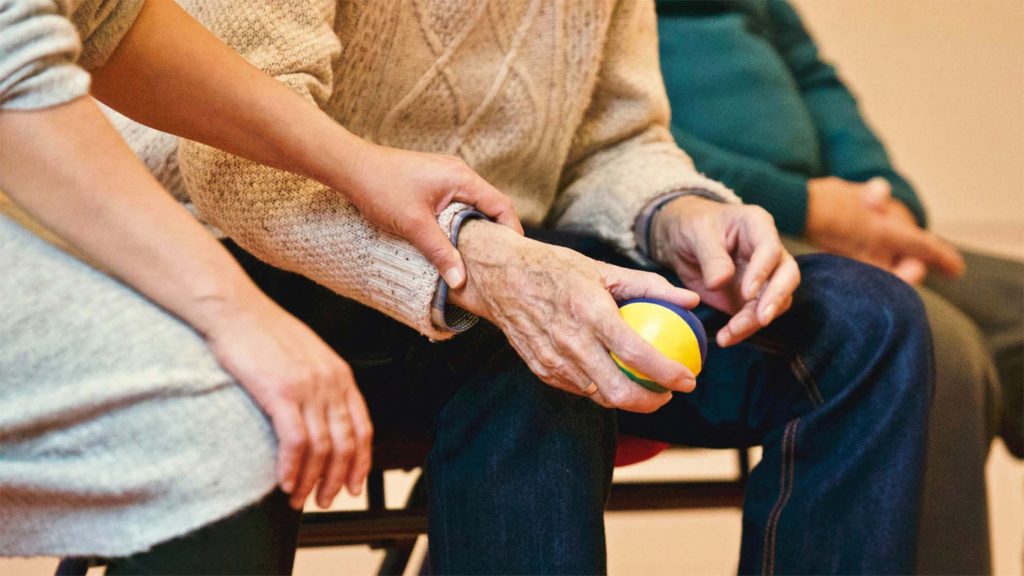 carer supporting resident whilst they play a ball game