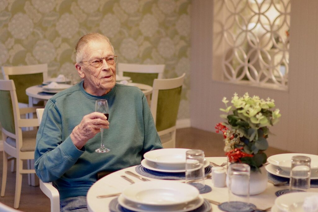 resident with glass of wine at mealtime