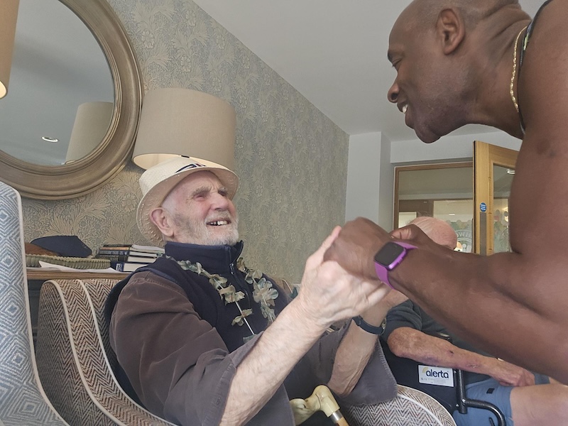 resident holding hands with an entertainer smiling