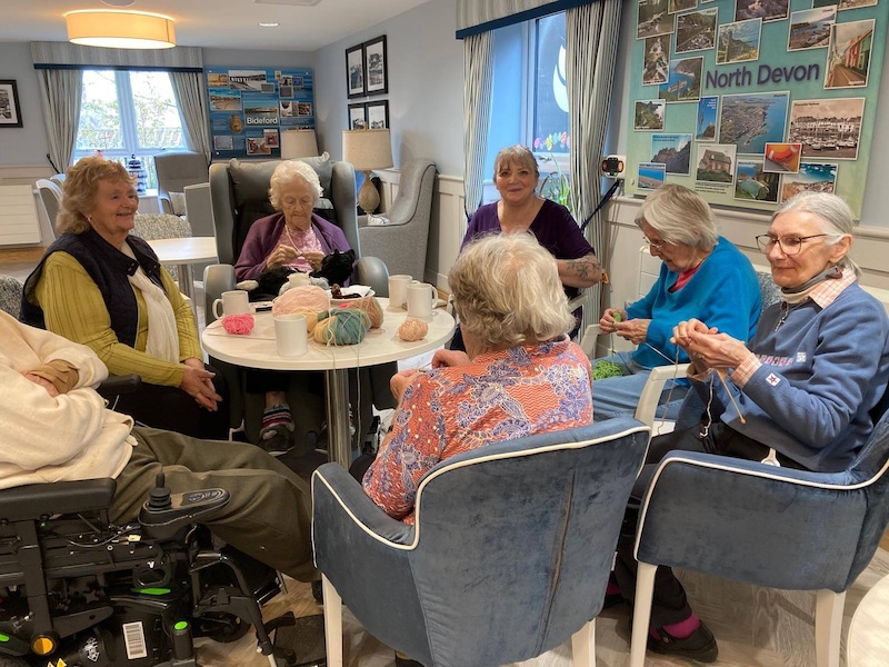 residents sat around the table together knitting