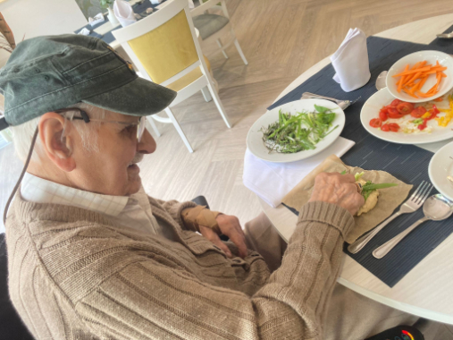 resident with hat on baking bread