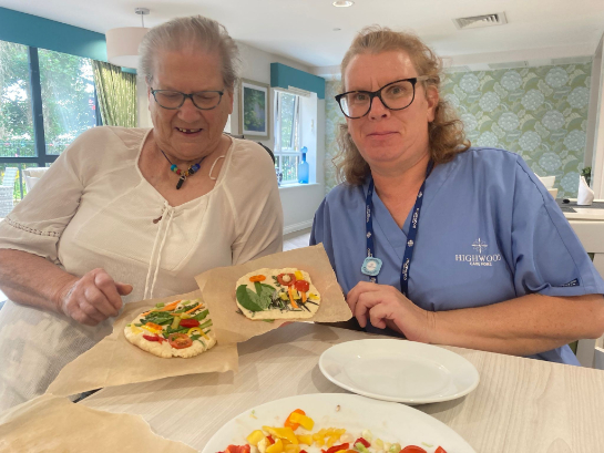 Resident and carer showing their bread art