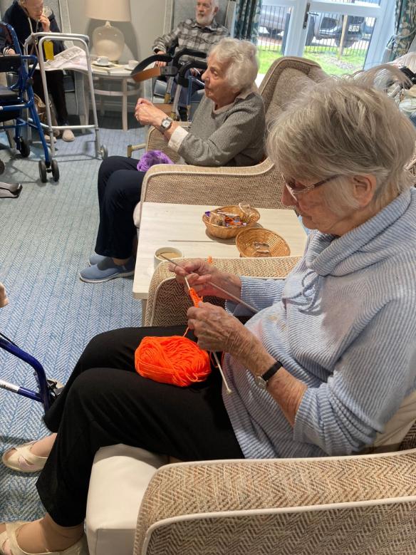 older lady knitting orange yarn