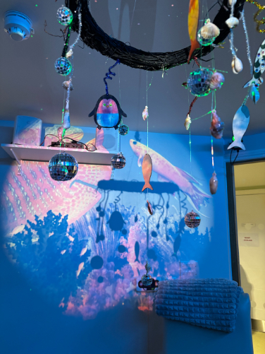 Colourful hanging art in the activity room at Highwood Care Home